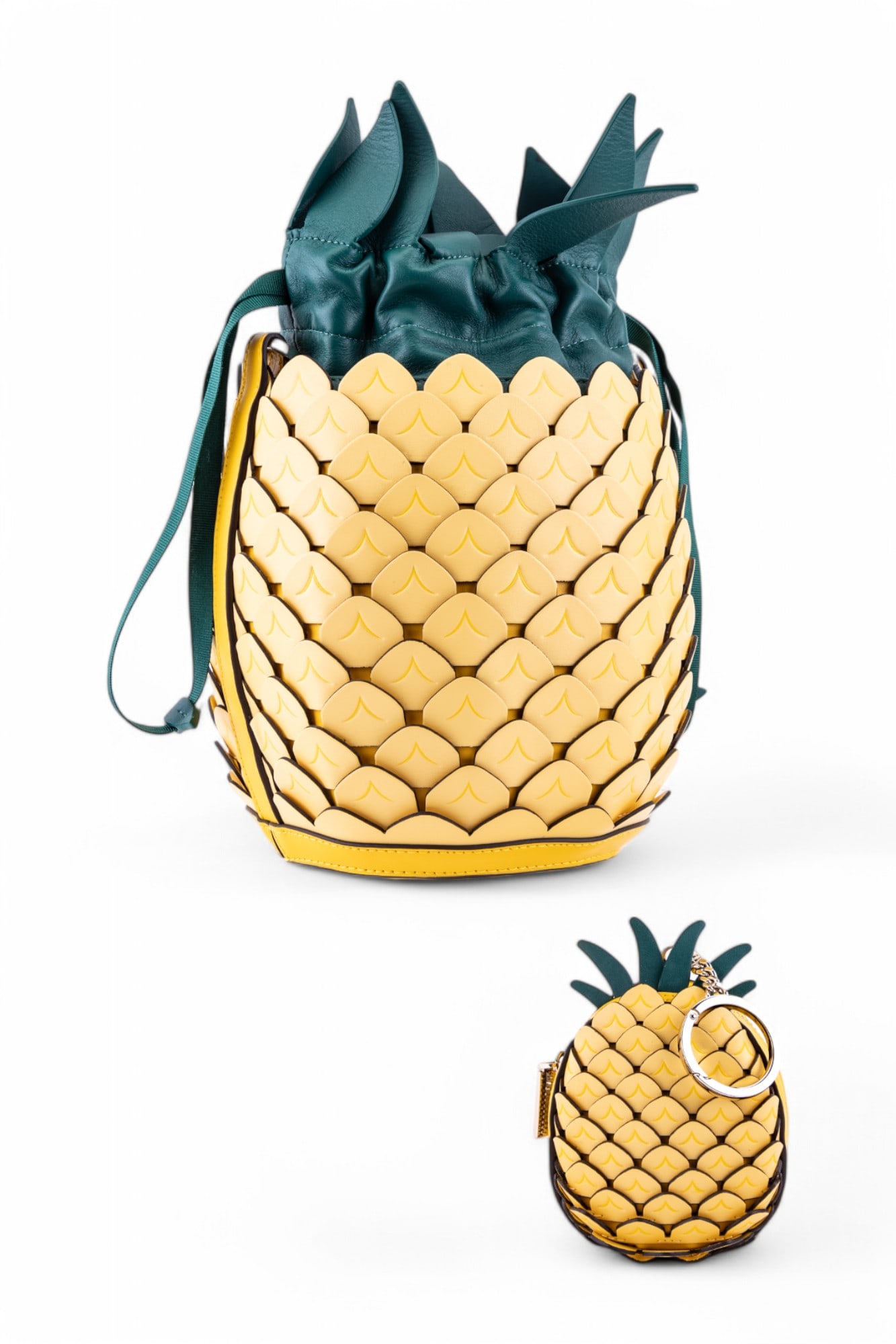 Kate Spade Pineapple-Shaped Leather Bag: Kate Spade leather crossbody bag shaped like a pineapple, featuring yellow panels with green leather leaf detailing and a drawstring closure. Includes a matching mini pineapple keychain or charm acces