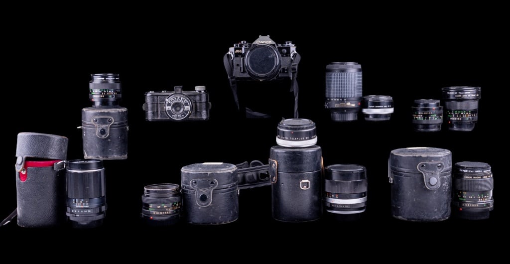 Canon A-1 & Falcon Miniature Cameras + Lenses (10): Vintage Canon A-1 camera, Falcon Miniature camera, 7 additional Canon lenses (3 in cases), a Nikon lens w/ Nikkor box, Takumar lens in case, & another lens made in Japan in case. Canon A-1 camera w/ 5