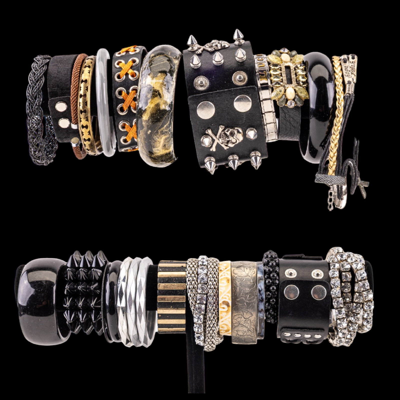 Alternative Jewelry Grouping: Grouping consists of one metal spike and crossbones bracelet, multiple leather bracelets, two silvertone chunky skull rings, six stretch rhinestone bracelets, two silvertone "scaled" bracelets, silver