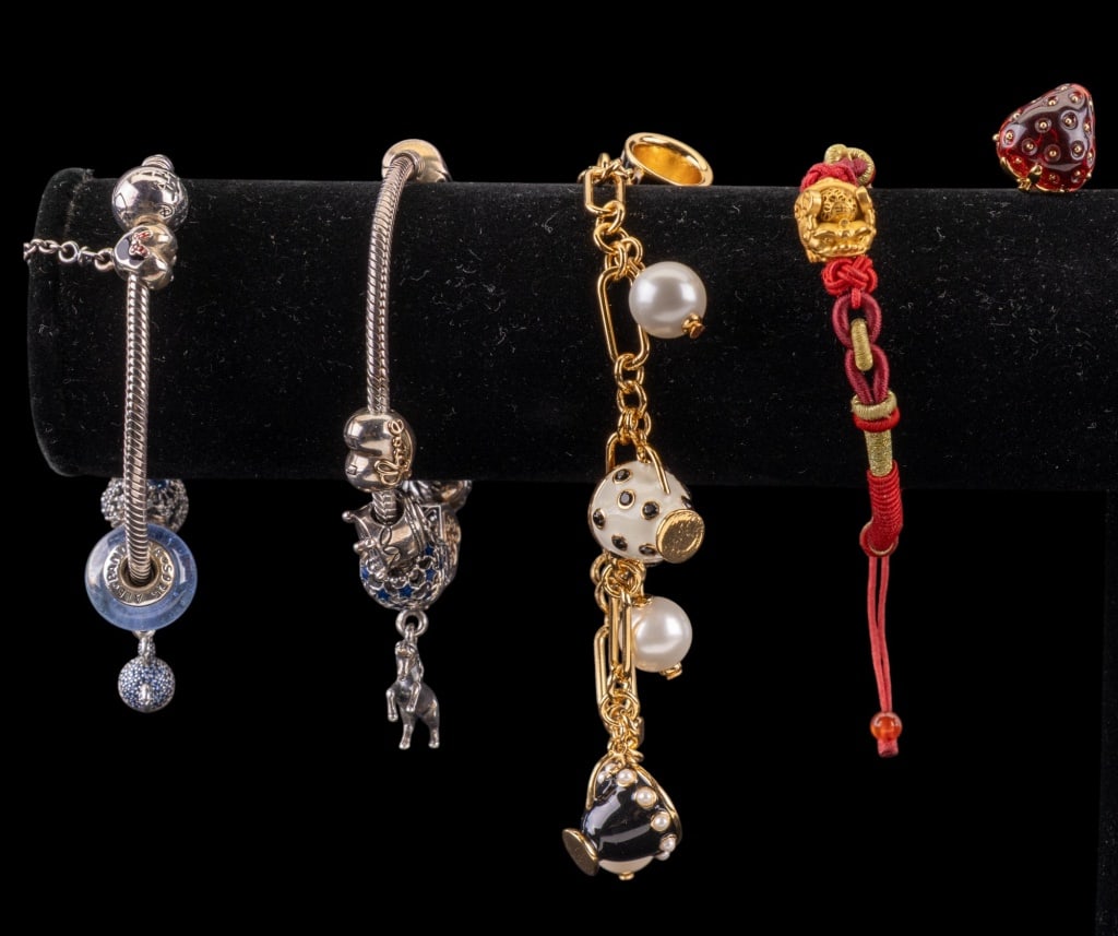 Pandora Sterling and Kate Spade Charm Bracelets: Two Pandora sterling silver charm bracelets including 13 charms, featuring Disney charms, reticulated hearts, stars, and snowflakes, one Kate Spade strawberry stud earring, Kate Spade faux pearl and e