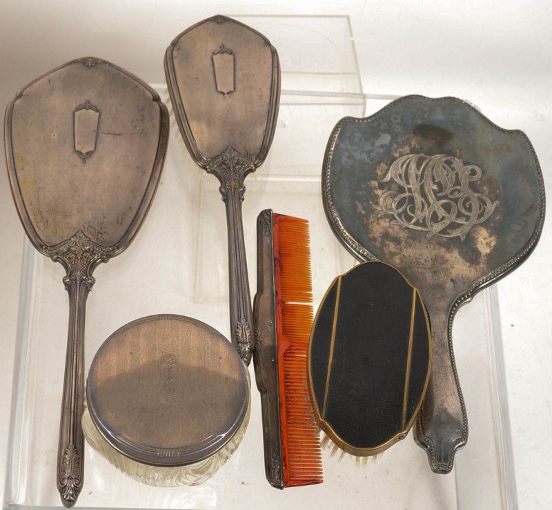 19th - Early 20th C Sterling Silver Dresser Set: with sterling silver brush, comb, mirror, as well as a glass and sterling powder jar, a sterling silver-handled magnifying glass and silver plated mirror and brass brush