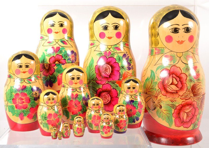 Matryoshka Doll (Nesting Doll): Traditional female matryoshka doll (Russian nesting doll) in gloss lacquer with floral on red; 14 graduated nesting dolls, largest doll is 13"h x 6"dia
