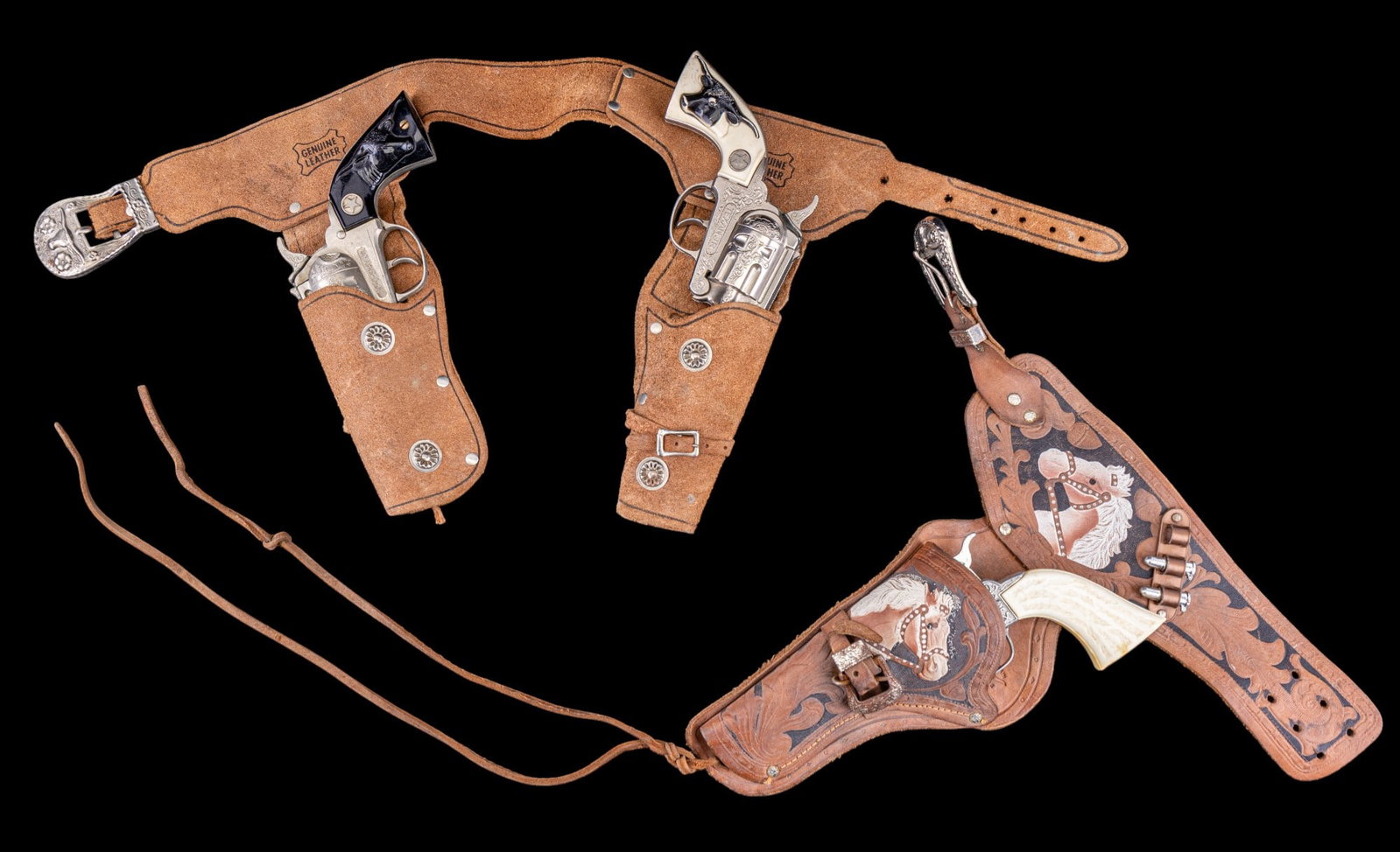 Western Toy Guns in Holsters and 2 Toy Bullets: Includes 2 semi-matching functional Hubley revolvers (1 Texan Jr. with white handle and 1 Ric-O-Shay Jr. with black handle) in a leather double holster and a "Pony Boy" revolver in a leather horse pai
