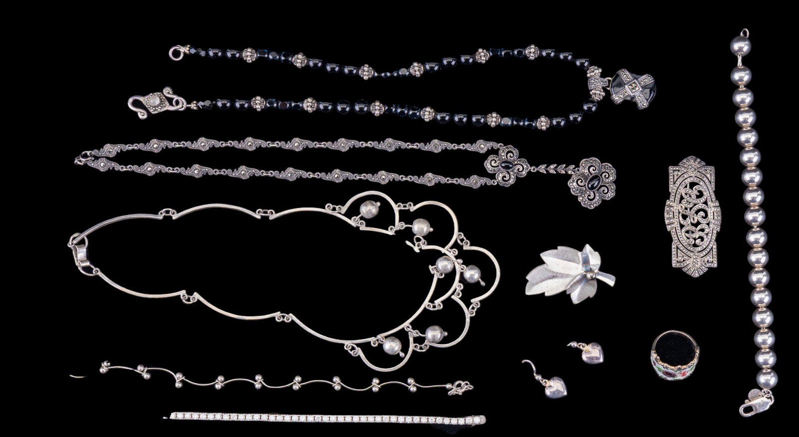 Tiffany, Jewelart, and Other Sterling Jewelry: A collection of fine sterling silver jewelry featuring an art deco necklace with black onyx cabochons, a black beaded necklace with sterling clasp and design accents, a jeweled and monogrammed art dec