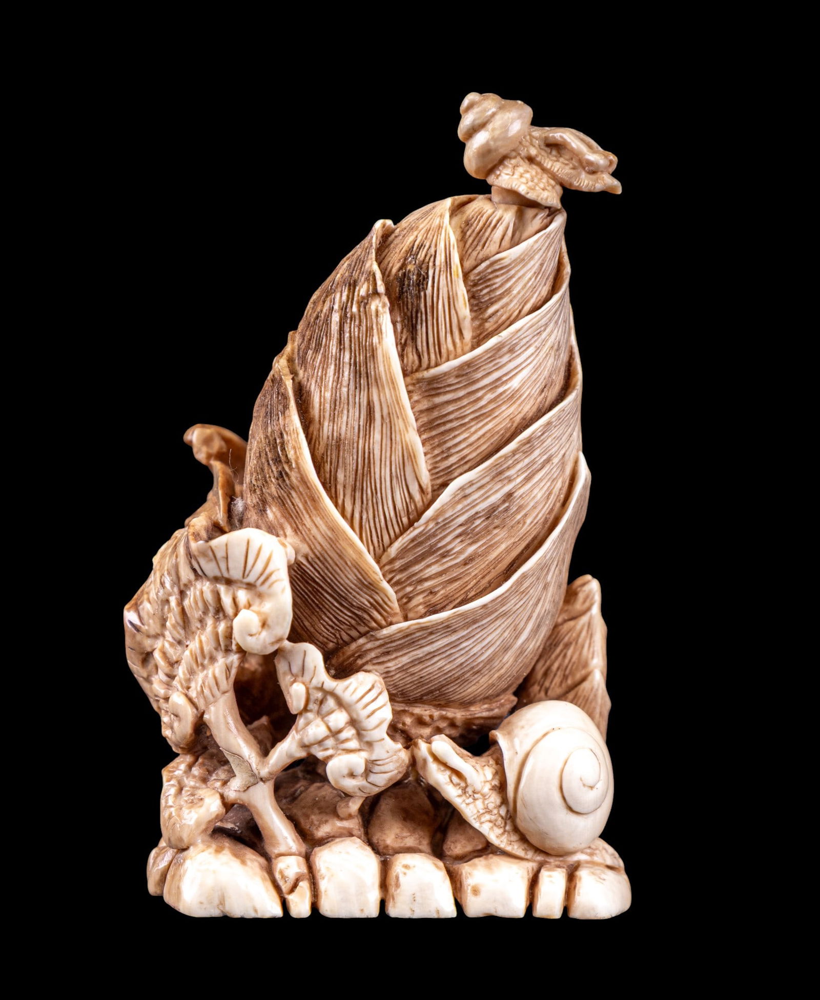 Carved Bone Okimono w/ Botanical & Snail Design: Japanese intricately-carved bone / natural material Okimono depicting a botanical scene w/ snails & a plant that resembles the ruyi symbol. Item measures approx. 2.5" tall, 1.5" wide, &1.25" deep. Ite