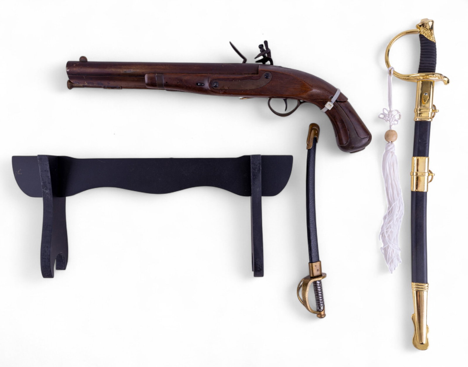 Civil War Swords and Pistol Replicas: Replica Harpers Ferry 1807 flintlock pistol with broken stock, measures 5.5" H x 16" W x 3.25" D, a C.S.A. replica sword on stand, and a smaller U.S. 1860 miniature replica sword.