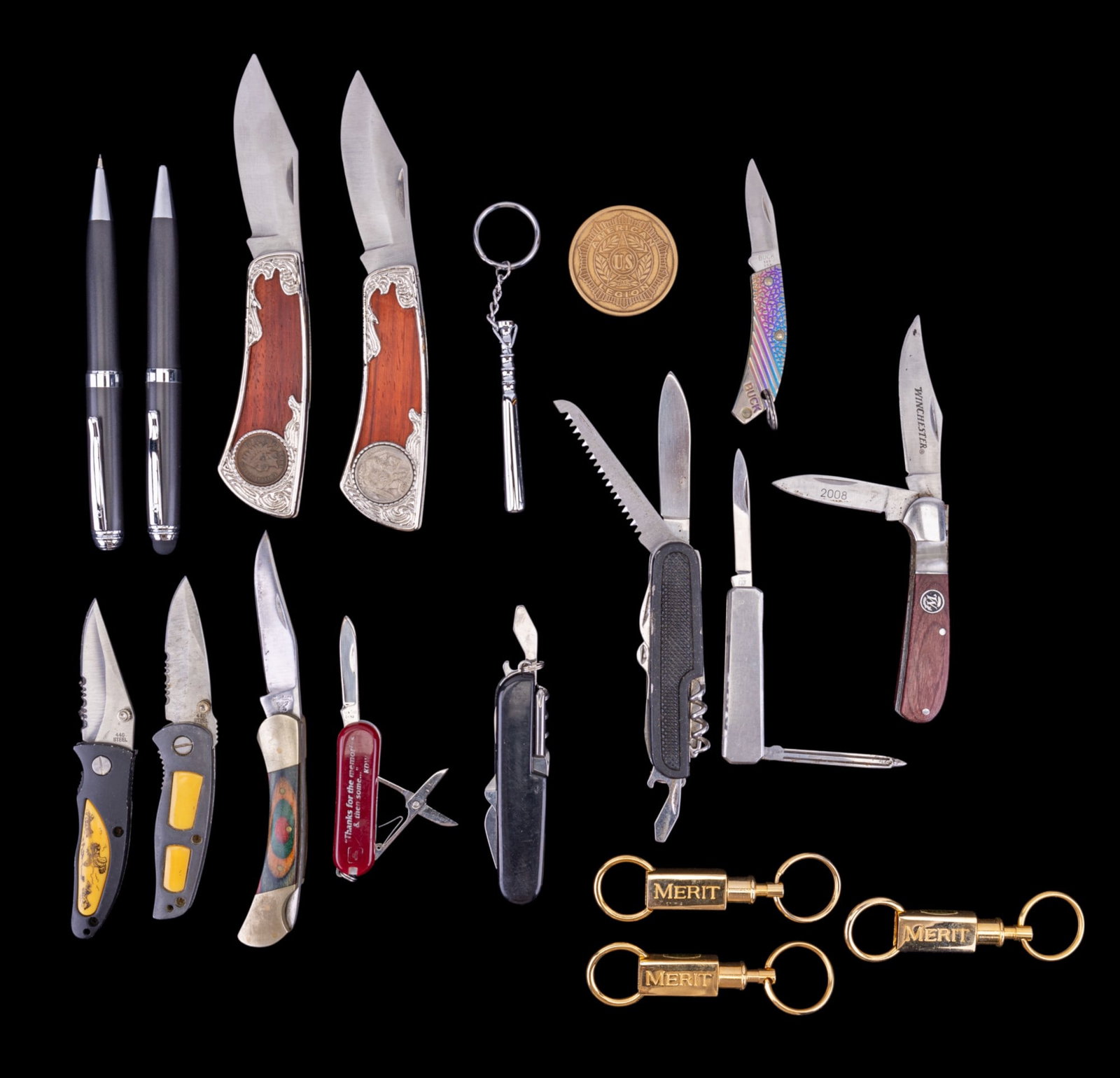 Pocket Knives, Key Chains, and Pen Set: A Pierre Cardin contemporary pen set featuring a ball point pen with stylus tip and matching mechanical pencil, three gold tone Merit Tobacco twist and lock key chains, a colored wood and brass handle