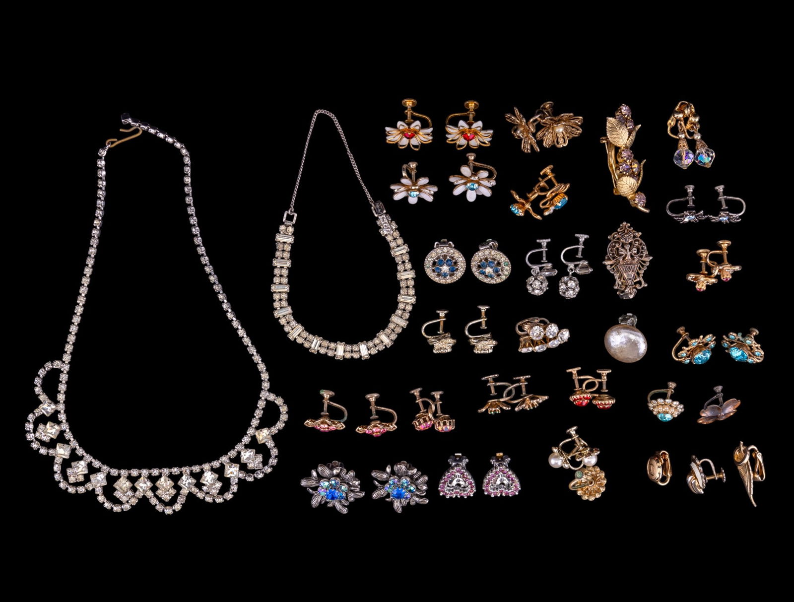 Vintage Estate Jewelry: A collection of vintage estate jewelry including various clip and screw back earrings with rhinestone crystal accents, early necklace and bracelet, and more.