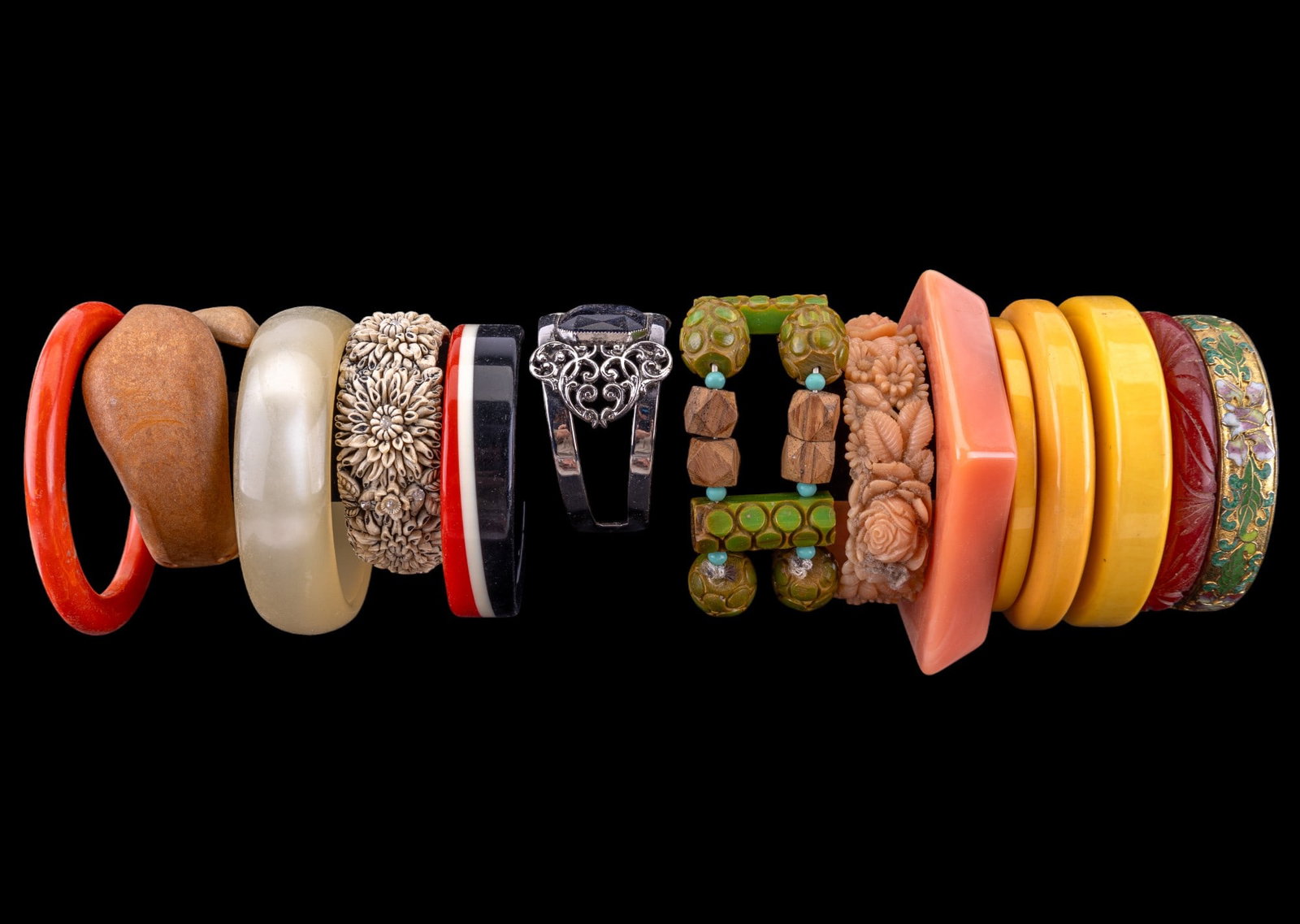 Bakelite, Carved, and Vintage Bracelets: Seven Bakelite bangles including green Bakelite beads with wood, carved red bangle, faceted burnt orange bangle, three vintage yellow bangles, gold tone cloisonne, and thirteen other bangle and cuff b