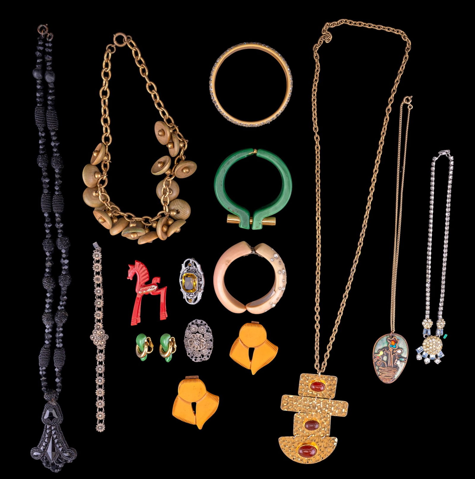 Bakelite and Other Vintage Jewelry: A collection of vintage jewelry including green hinged bracelet with matching clip on earrings by Trifari, yeloow Bakelite clip/buckle, celluloid and rhinestone bracelts, vintage pins, and more.