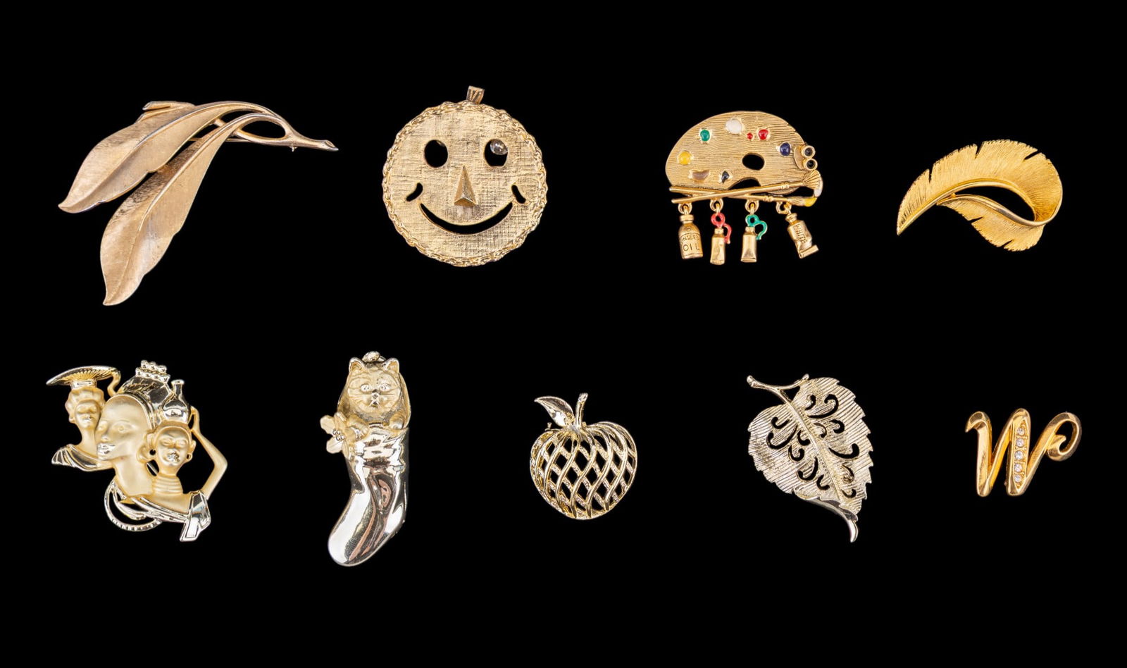 Crown Trifari, Danecraft, A.J.C, more Brooches: Grouping includes a mid century Crown Trifari gold tone leaf brooch, a Danecraft Painter's Pallet gold tone brooch, J.J marked gold tone leaf brooch, A.J.C gold tone brooch of a dog in stocking, two G