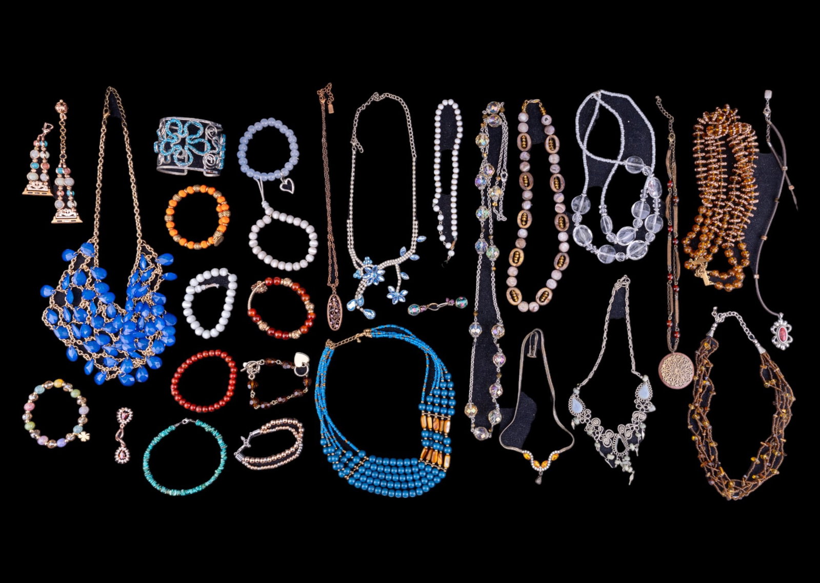 Turquoise Style, Rhinestone + More: An assorted jewelry lot featuring various pieces, including turquoise style, art glass earrings, a copper-esque necklace marked '1928,' and multiple pieces crafted with natural stones. Also included a