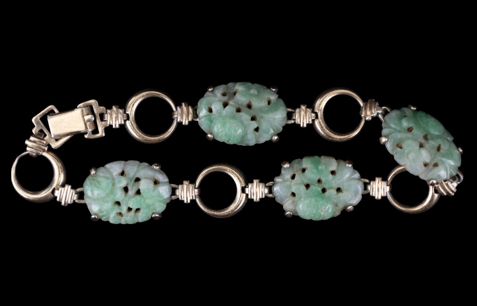 GF & Sterling Silver Carved Green Jade Bracelet: A gold filled and sterling silver carved green jade bracelet measuring approx. 8" long with four carved green jade panels.