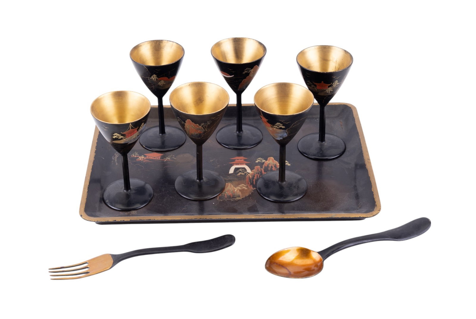 Vintage Black & Gold Lacquerware: A collection of vintage black and gold Lacquerware including a hand painted tray depicting pagodas, mountains, and clouds. Also included are 6 small wine glasses with matching imagery, 1 wooden dinner