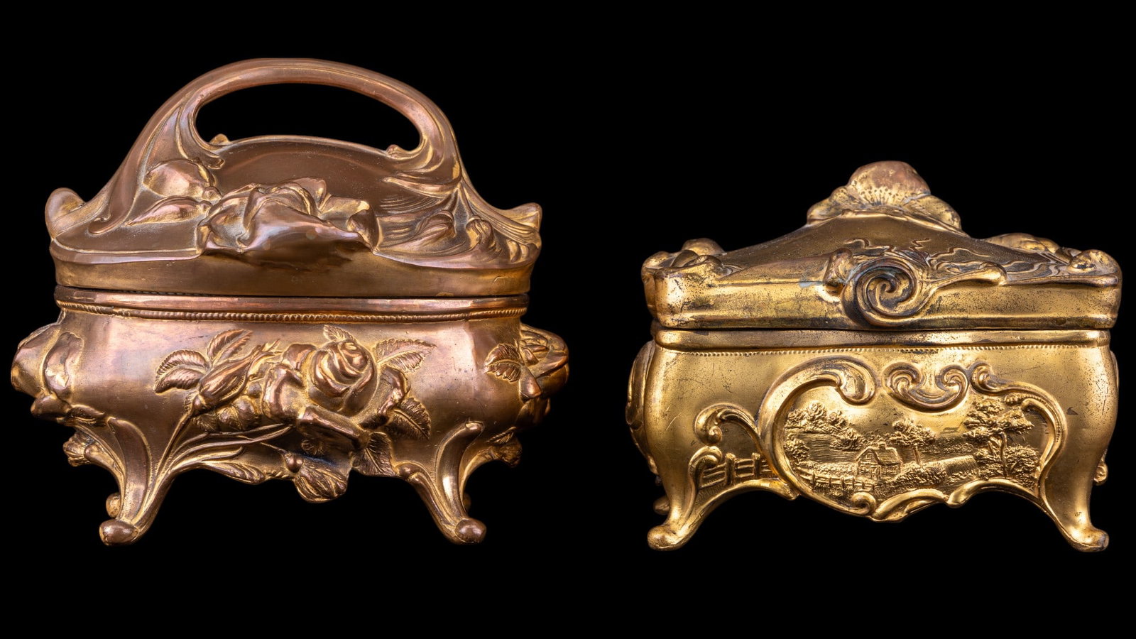 2 Early B&W Footed Brass Vanity Boxes: 2 B&W Footed Brass Vanity Boxes, taller of 2 measuring approx 5" H x 6" W. Floral and countryside scenes.