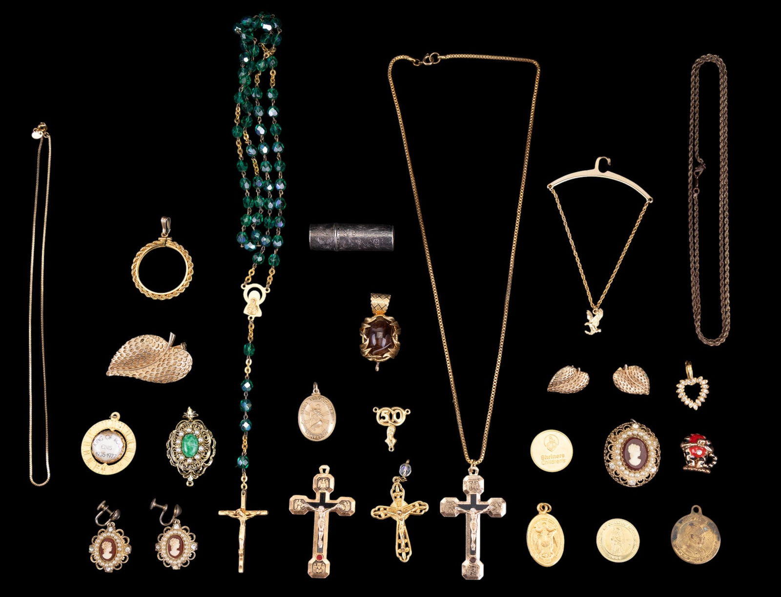 Vintage Gold Tone Pendants and Religious Jewelry: Vintage cameo and faux pearl screw back earrings and pendant set by Coro, a gold tone leaf brooch and clip on earring set by Roma, an early incised silver tone Revlon lipstick holder, a spinning Elvis