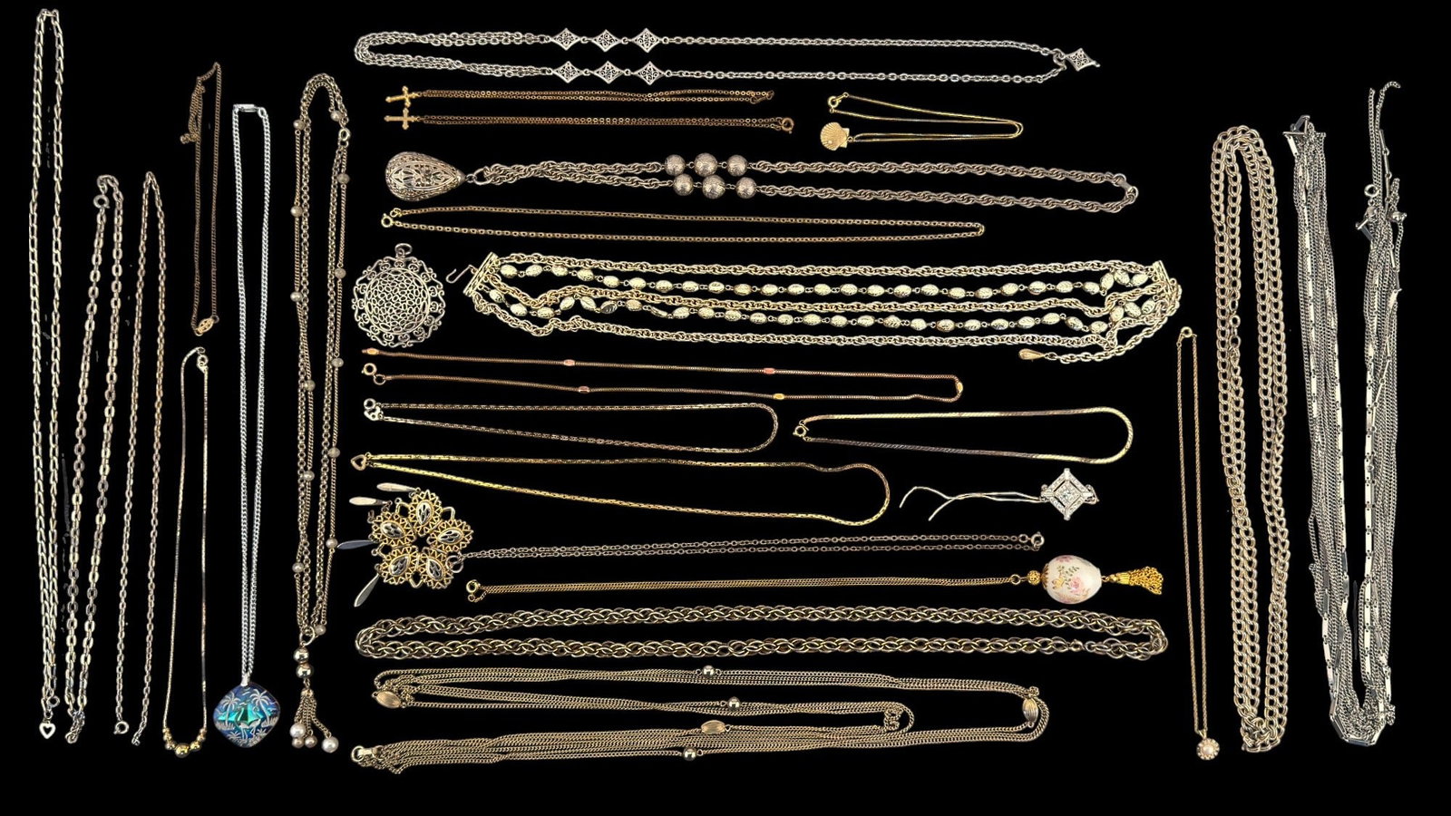 Costume Necklaces and Chains w/ Trifari: A collection of gold tone and silver tone chains and necklaces, featuring a gold tone and pearl Trifari necklace and pendant, oversized silver tone pendants, multi strand necklaces, and others.