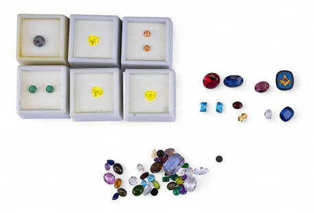 Loose Precious and Semi Precious Gemstones: A collection of loose precious and semi precious gemstones featuring a large round cut red-pink stone that tests for ruby, a large oval cut blue stone that tests for topaz, two small emerald cut light