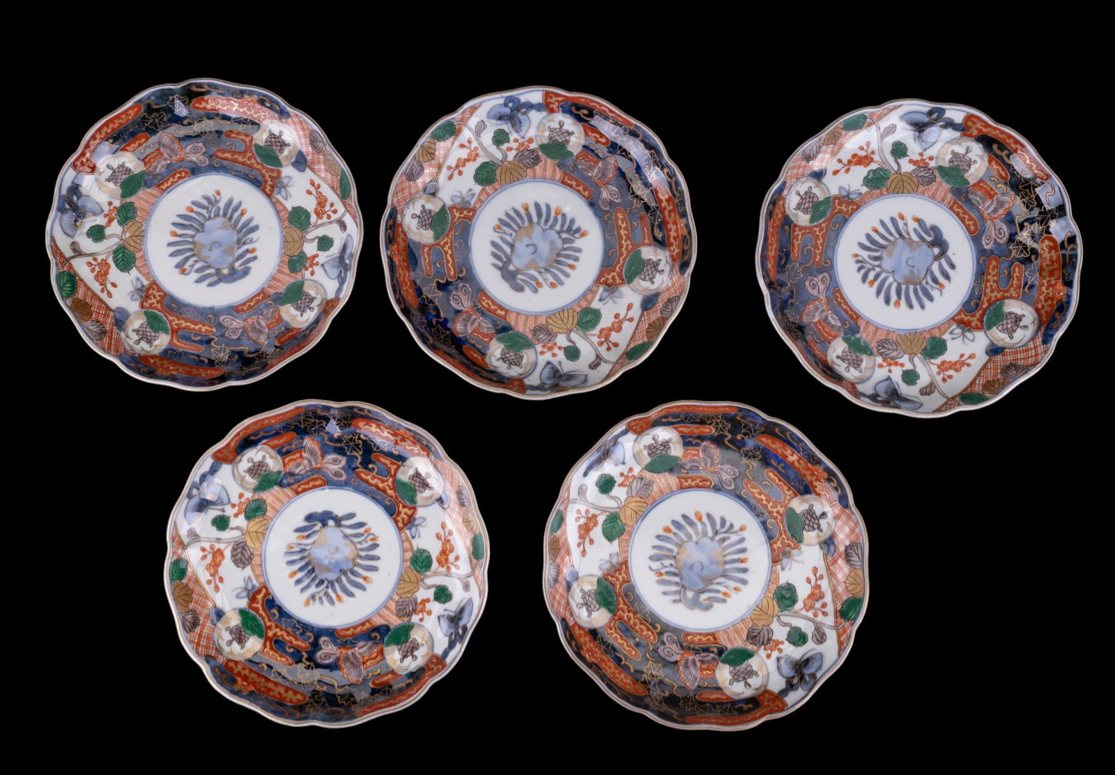 Japanese Scalloped Imari Porcelain Plates (5): A grouping of 5 matching Japanese Imari plates, each with a scalloped rim and traditional hand-painted decoration in under glaze blue, iron red, and gilt, depicting a chrysanthemum bloom surrounded by