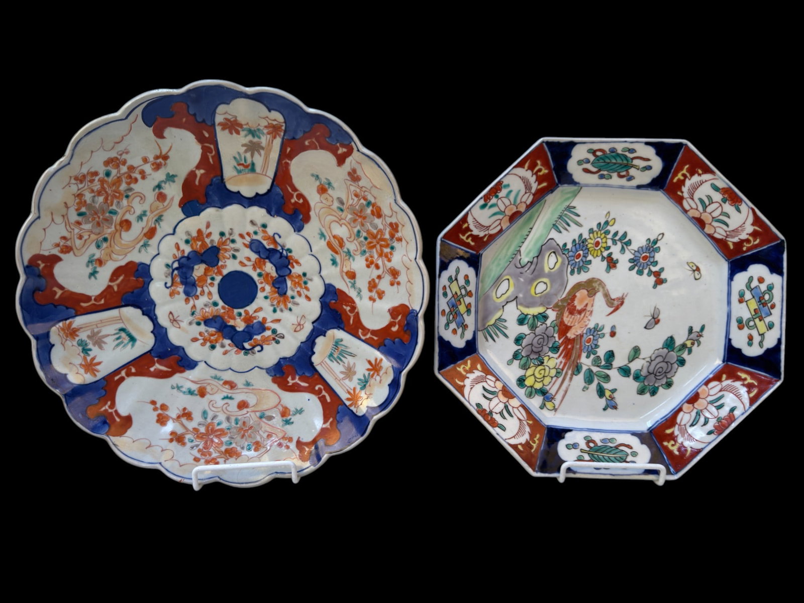 Antique Japanese Imari Chargers (2): A pair of 19th-century Japanese Imari porcelain chargers. One charger features a octagonal rim with a central peacock among flowers with a red and blue border of auspicious plants, while the other sho