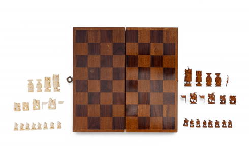 Hand Carved Asian Figural Chess Set w/ Box: A vintage handcrafted chess set featuring intricately carved figural pieces in 2 contrasting colors- cream and amber tone- housed in a folding inlaid wood chessboard box with fitted interior compartme