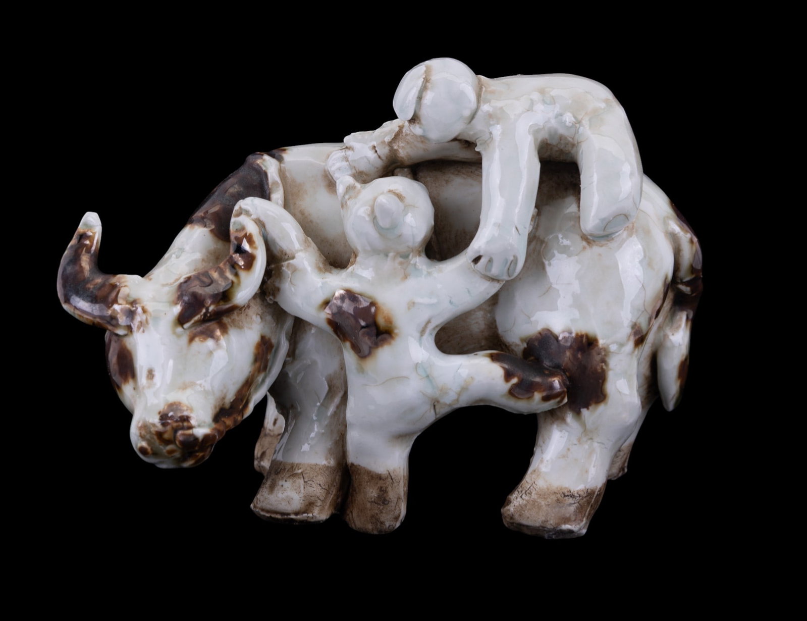 Herding Boys and Ox Figurine: An early Chinese porcelain figurine depicting herding boys climbing on an ox, not signed, measures approx. 6.25" W x 3" D x 4.5" H.
