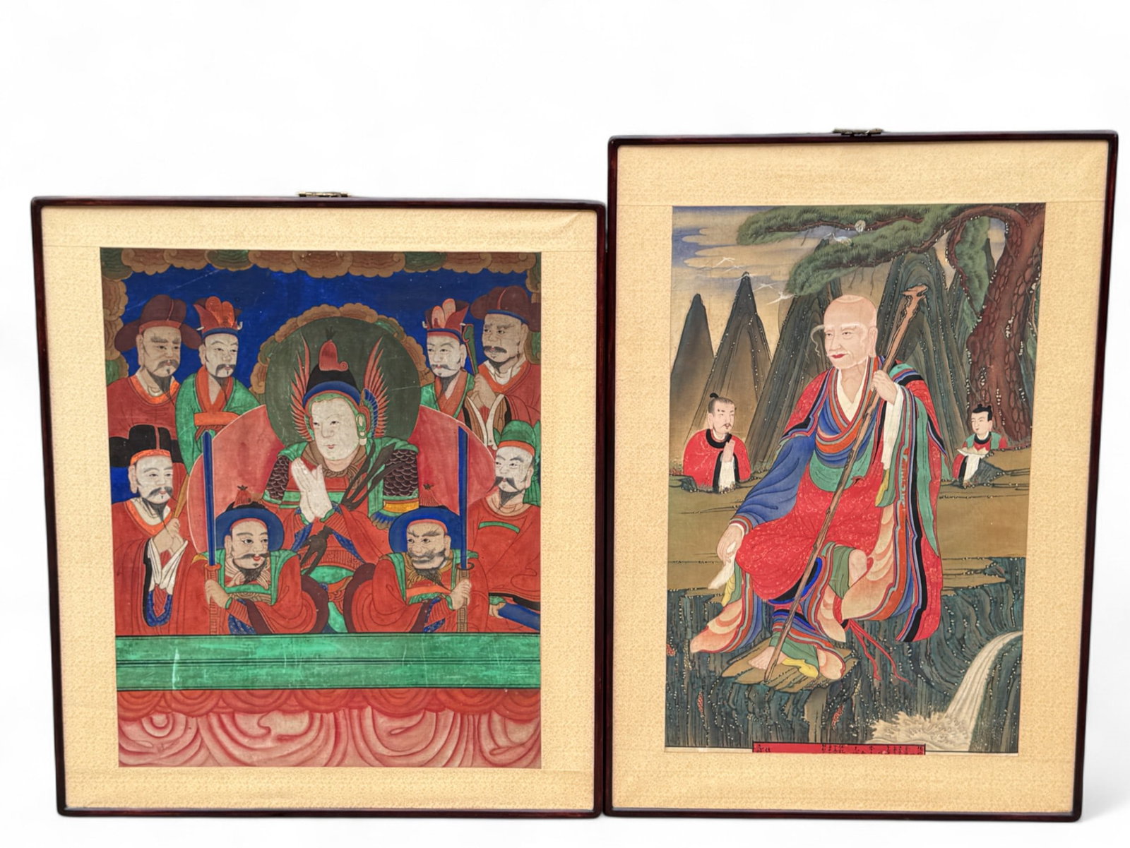 Hand-Colored Japanese Woodblock: A framed Japanese woodblock depicting an elderly figure in colorful robes seated on a rocky outcrop, accompanied by 2 attendants, set against a scenic landscape of mountains, pine trees, and flowing w