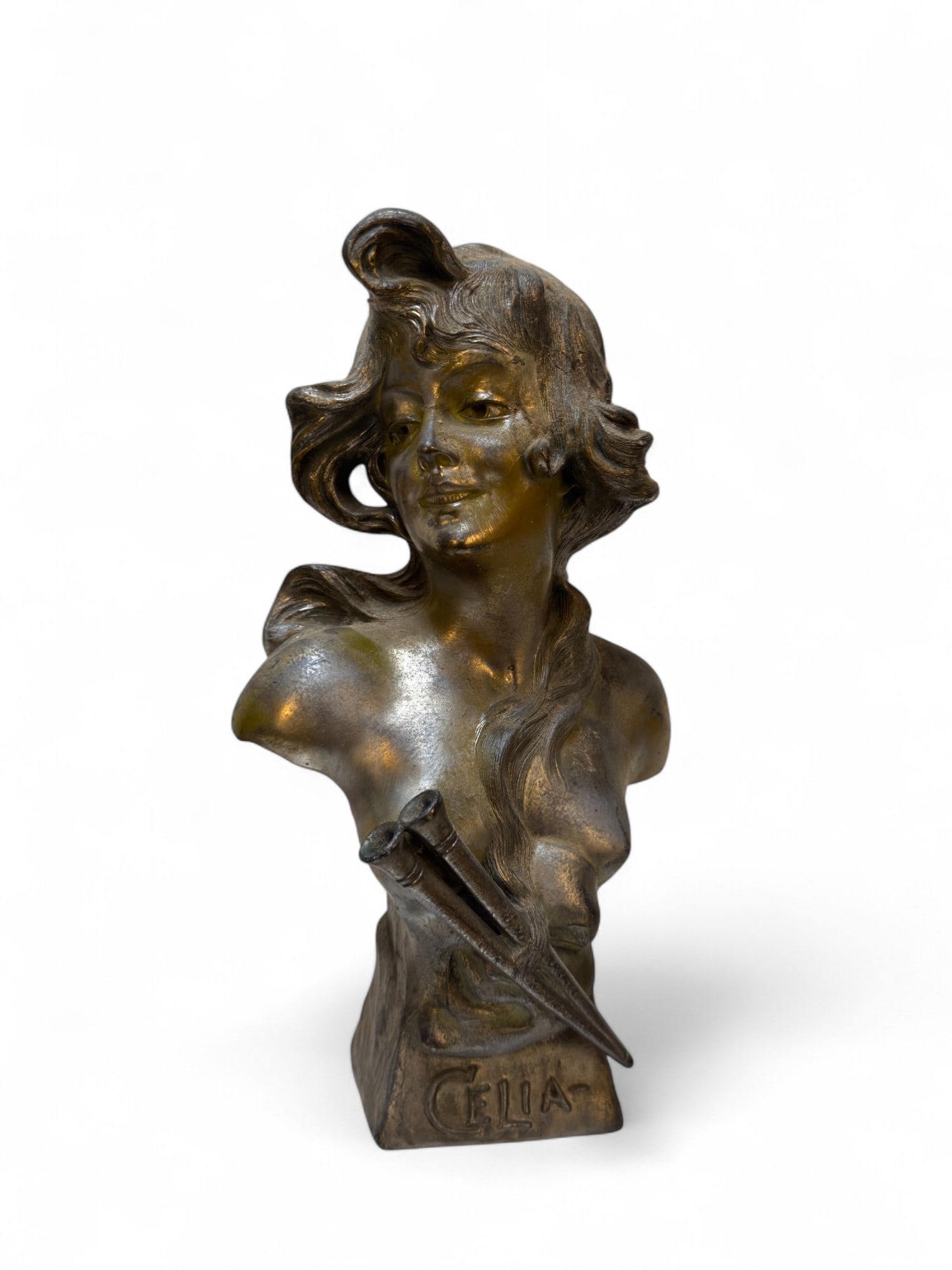 Art Nouveau Bust of a Woman "Celia": A cast metal Art Nouveau bust of a woman with flowing hair, inscribed "CELIA" on the front. 2 instruments can be seen on front. Condition is as seen, dusty. Approx 11.5" H x 7" W, base 3.5" x 2.5".