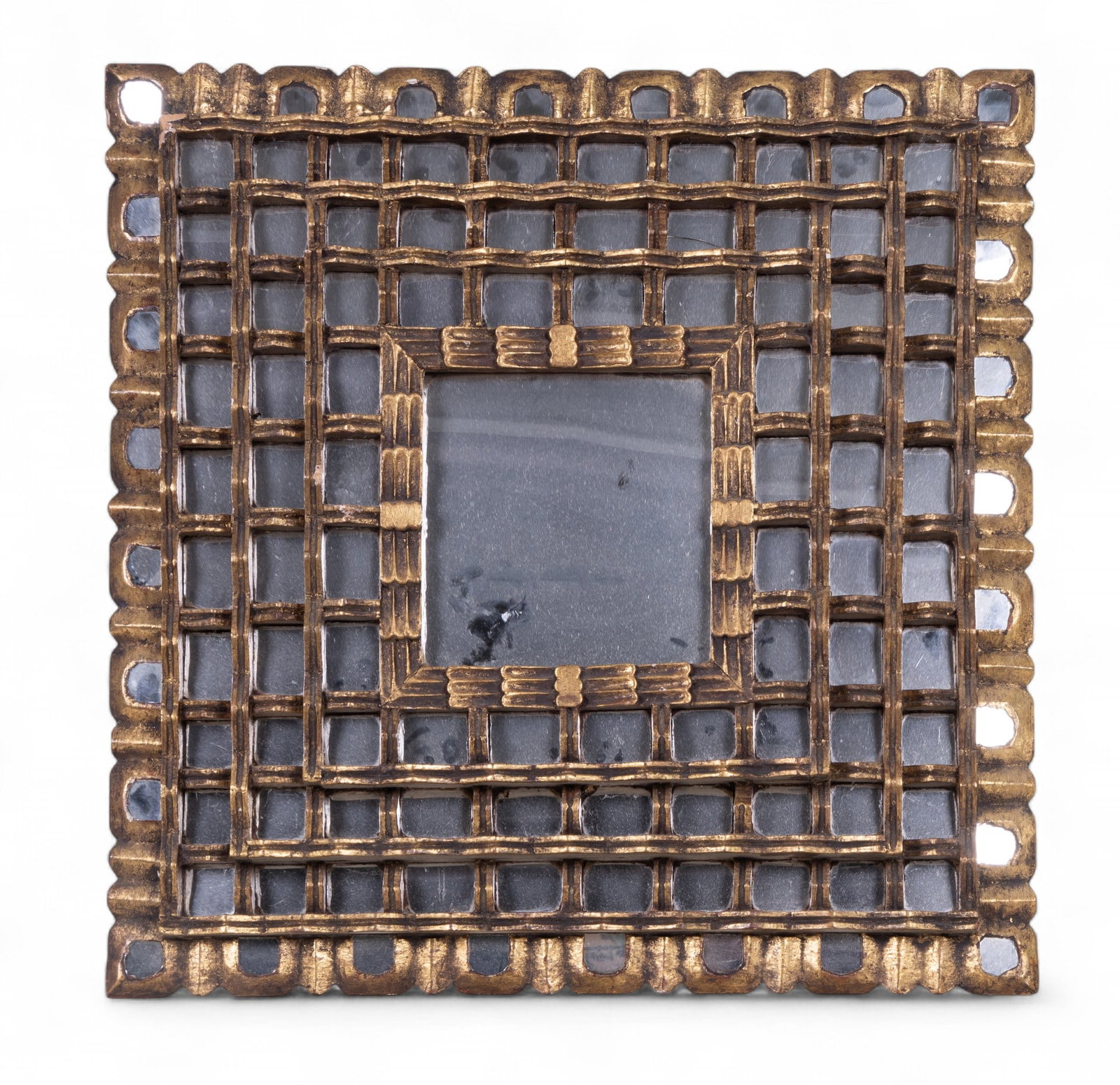 Unusual Brutalist Gilt Carved Mirror: An usually carved Brutalist mirror featuring a square frame with geometric openwork grid design and gilt finish. Measures approx. 26" H x 26" W.