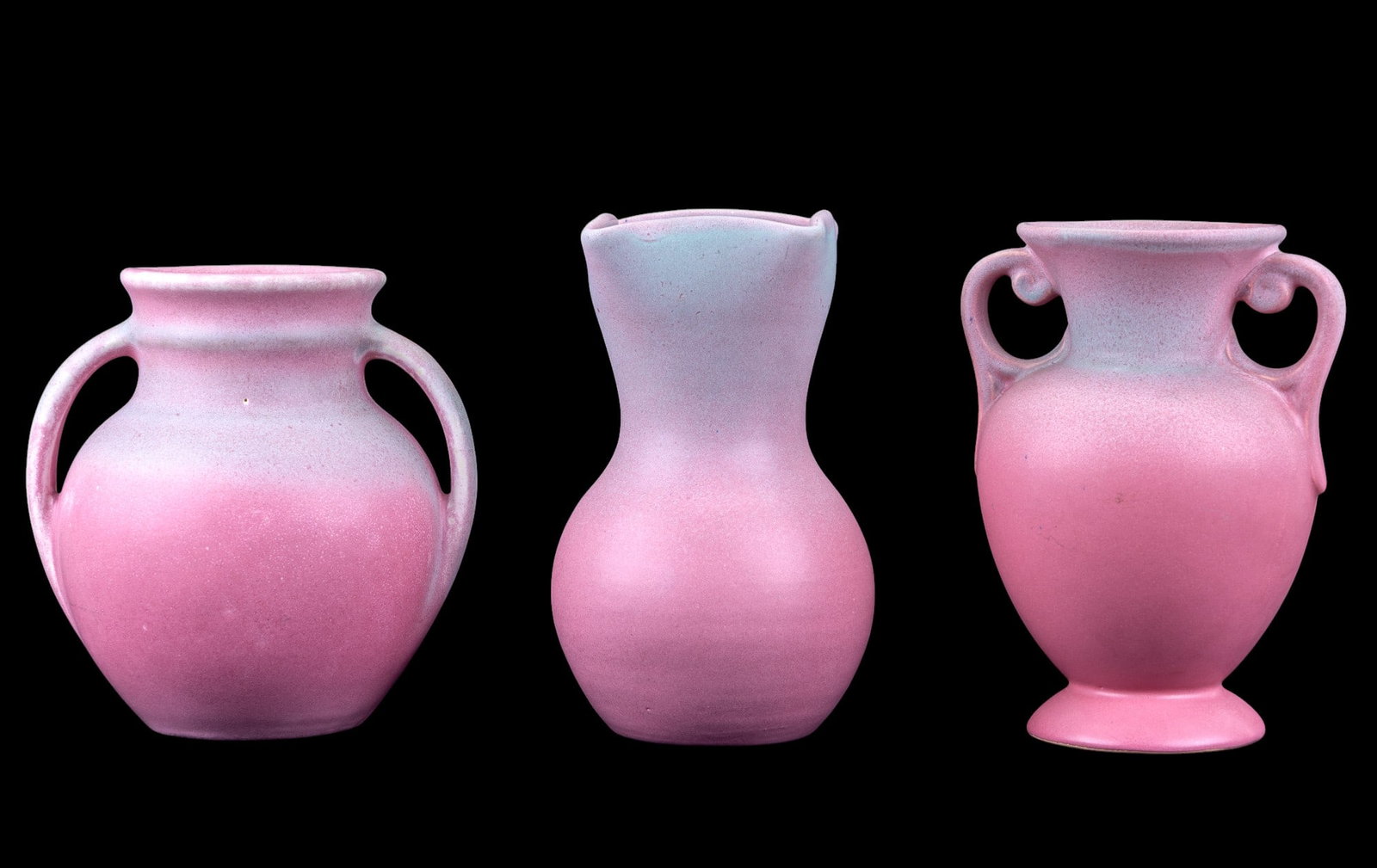 Niloak Pink Gradient Ceramic Vases: A collection of two Niloak and one hand signed Hyalyn matte glazed pink and green gradient vases featuring styles such as a two handled amphora style, a two handled jug style, and a Hyalyn vase with a