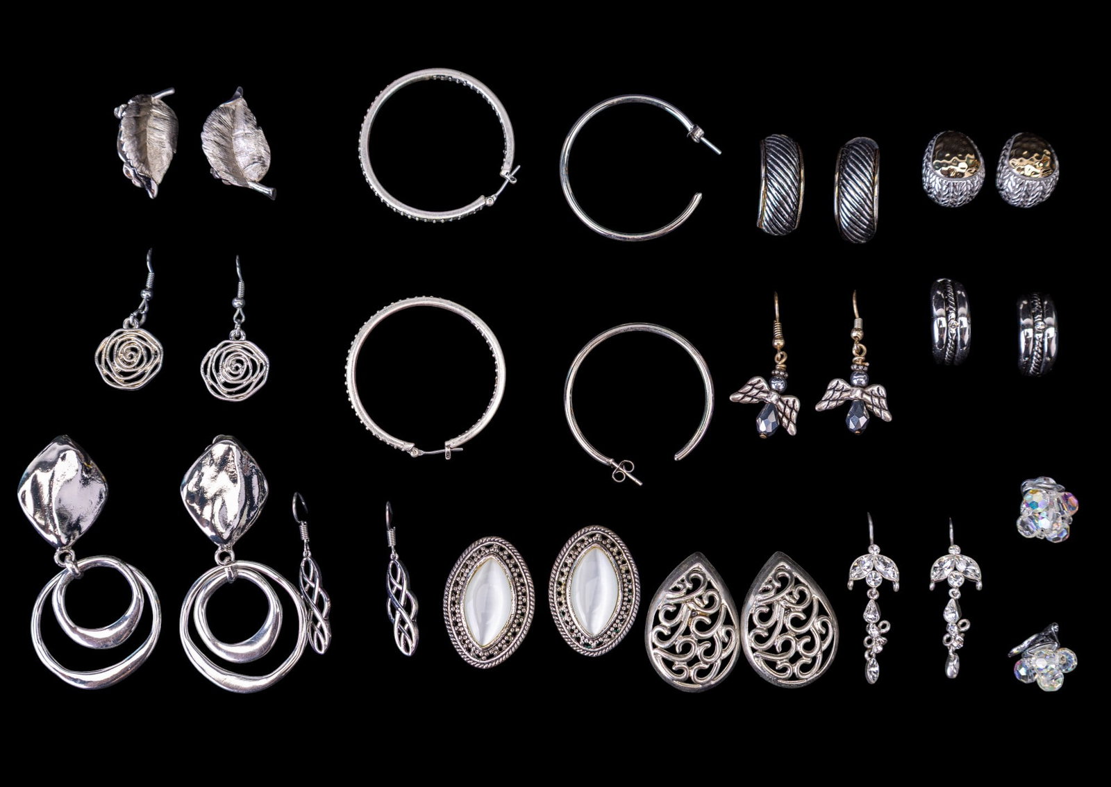 Silver Tone Costume Earrings: A collection of silver tone costume earrings featuring silver tone leaf clip ons by Trifari, hoops with rhinestones, stud, drop, French hook, and a pair of clip on earrings marked Made in Austria with