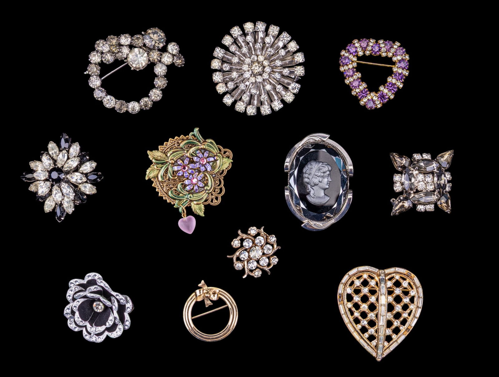 Brooches and Pin Jewelry: 11 brooches and pins including a Trifari heart brooch with rhinestone pendant, a gold-tone circle pin with ribbon marked 12 karat gold-filled, and nine additional unmarked brooches featuring various d