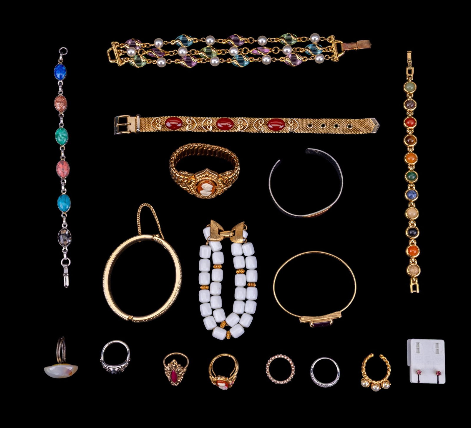 Vintage Costume Jewelry: A collection vintage costume jewelry including gold and silver tone cuff bracelets, featuring designers such as Sarah Coventry and Avon, a gold tone and carnelian belt bracelets, multi-strand bracelet