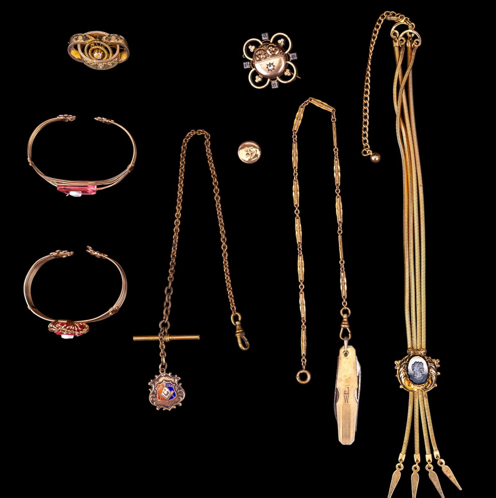 Victorian Gold Filled Jewelry: A collection of Victorian gold filled jewelry featuring two wire wrapped cuff bracelets with clear pink cut stone cameos, a a two strand tassel necklace with ornate hematite cameo pendant, an enameled