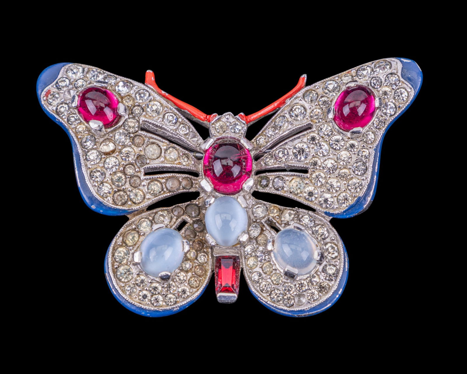 Trifari Fine Vintage Butterfly Brooch: Very fine vintage Trifari butterfly brooch featuring multiple clear rhinestones, enamel edge details, and ruby and moonstone colored cabochons.