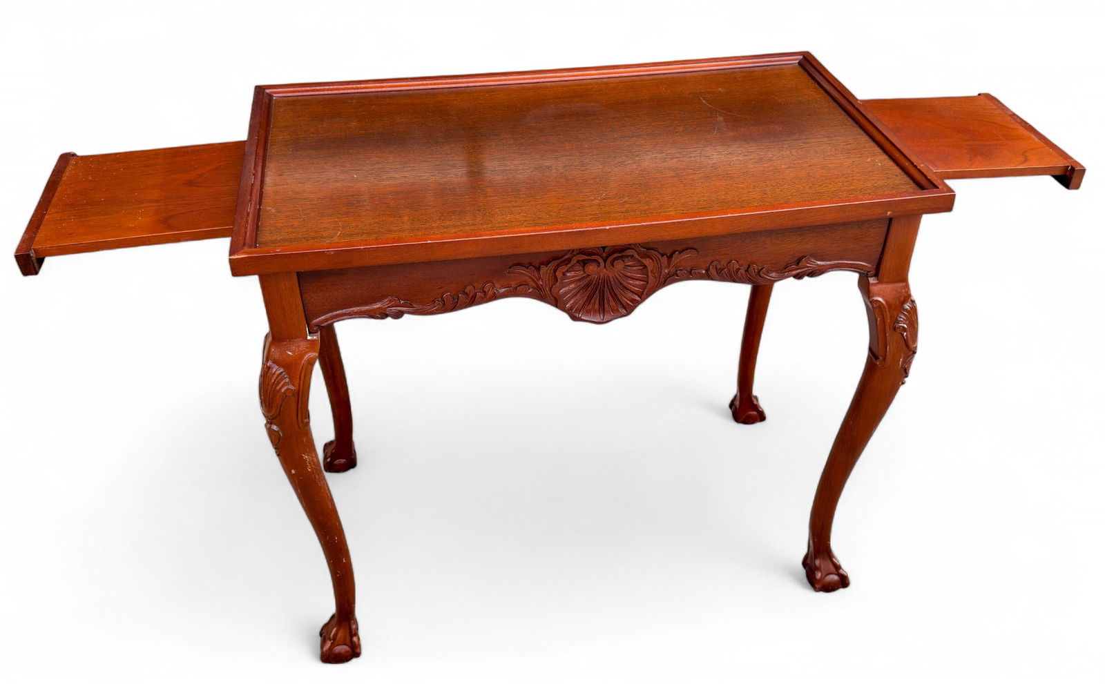 Carved Mahogany Tea Table w/ Pullout Trays: Carved mahogany tea table with pull-out trays / candle trays, carved knee and skirt with shell design, ball and claw feet. Measures approx. 26.5" H x 31" W x 18" D.