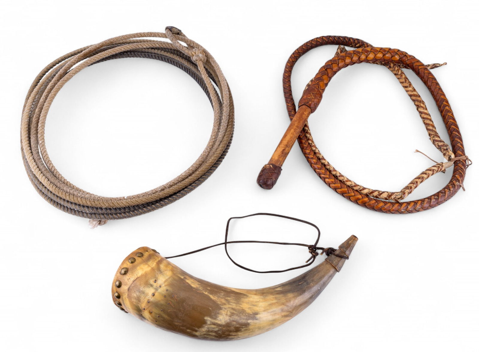 Leather Whip, Lasso, Carved Powder Horn: A vintage braided leather whip with significant fraying, a this jute rope lasso, and a vintage incised and carved powder horn, measuring approx. 15" L.