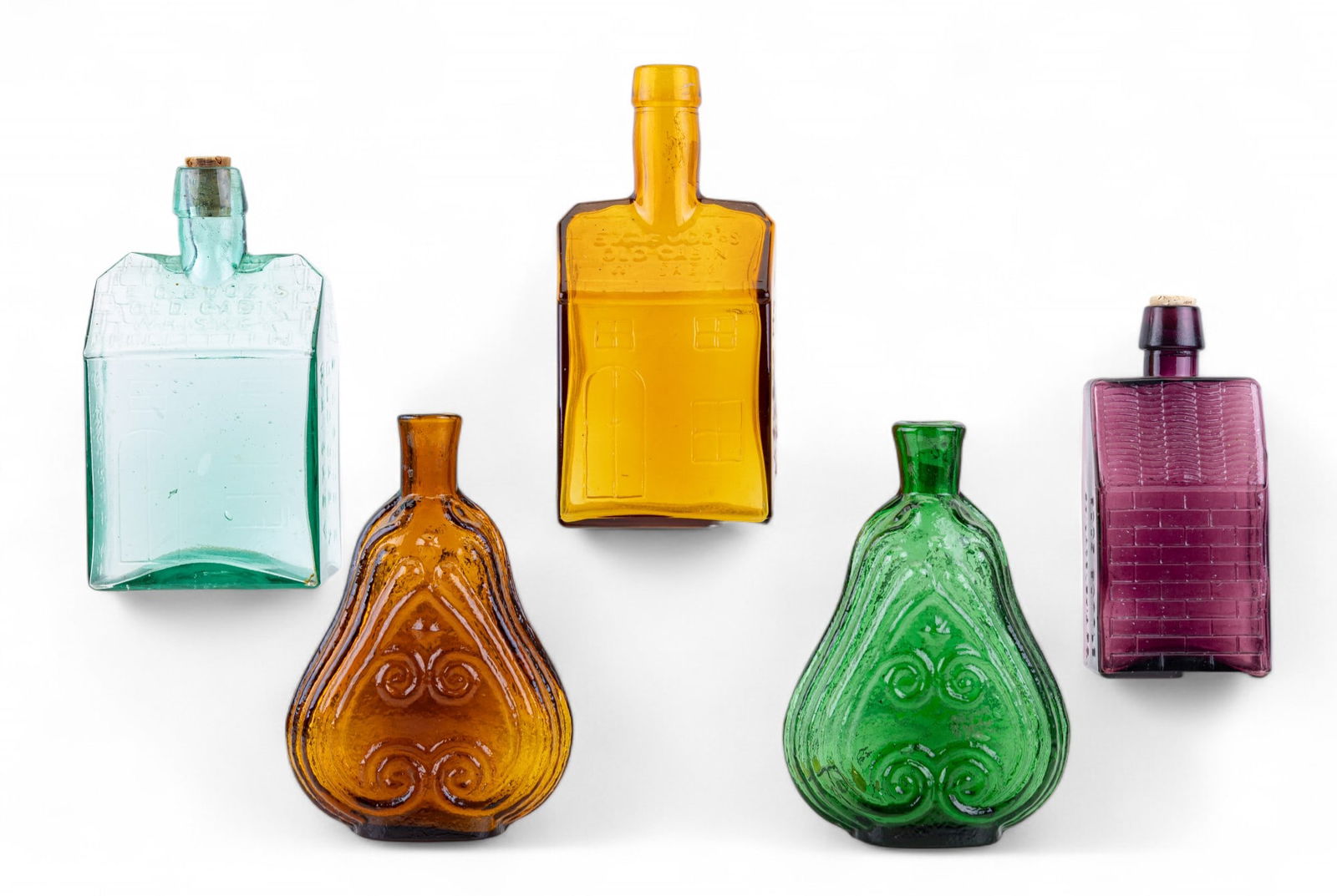 Vintage Historical Colorful Glass Bottles (5): Group of colorful vintage glass bottles in the style of 19th-century American flasks and whiskeys, including 3 E.G. Booz's Old Cabin Whiskey bottles in amethyst, aqua, and orange, figural "scroll" fla