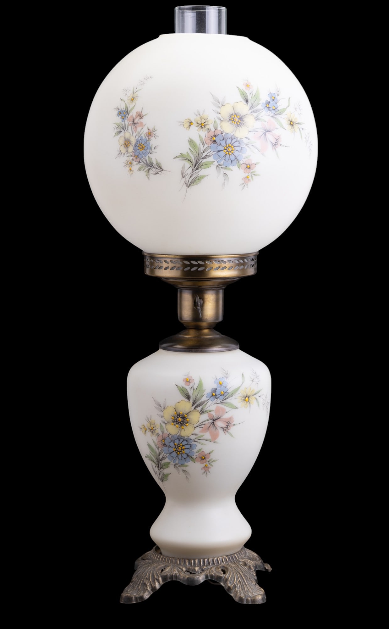 Vintage Hurricane Lamp w/ Floral Design: Vintage white glass hurricane lamp w/ pastel floral design & decorative brass base. Item measures approx. 22.5" to top of chimney & 5.5" x 5.5" at the base. Globe shade is approx. 9" in diameter. See