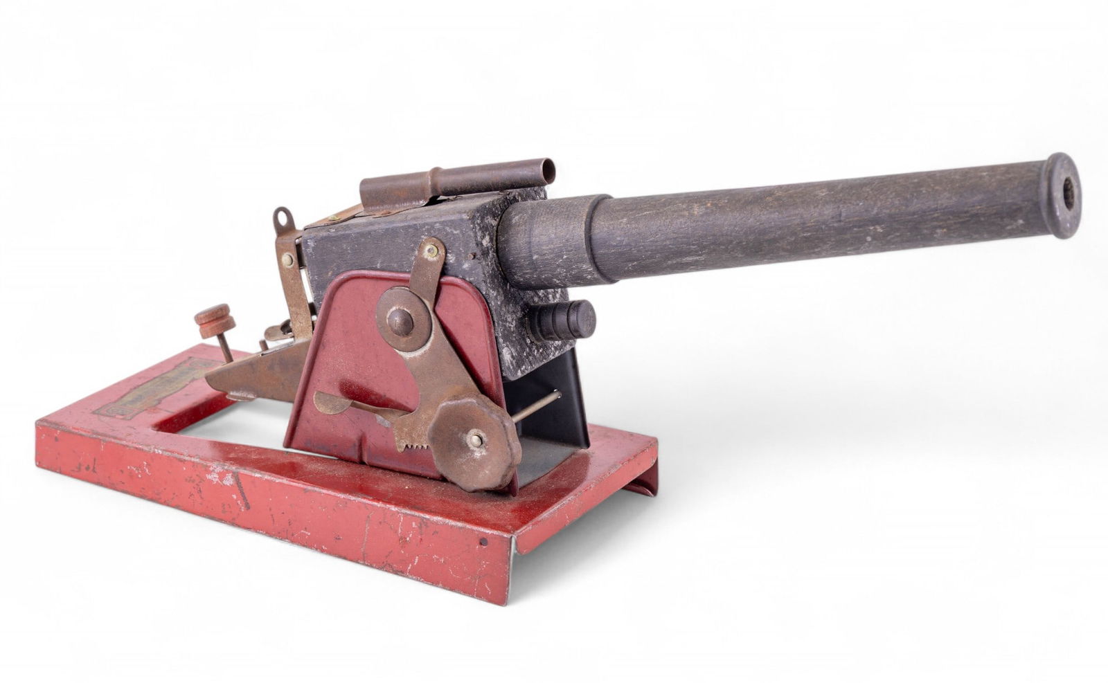 Baldwin Mfg. Co. Toy Cannon: Wooden toy cannon with metal firing mechanism and fittings, made by Baldwin Manufacturing Company, Brooklyn, New York. Mounted on a red-painted metal base with Baldwin label marked "No. 890". Measures