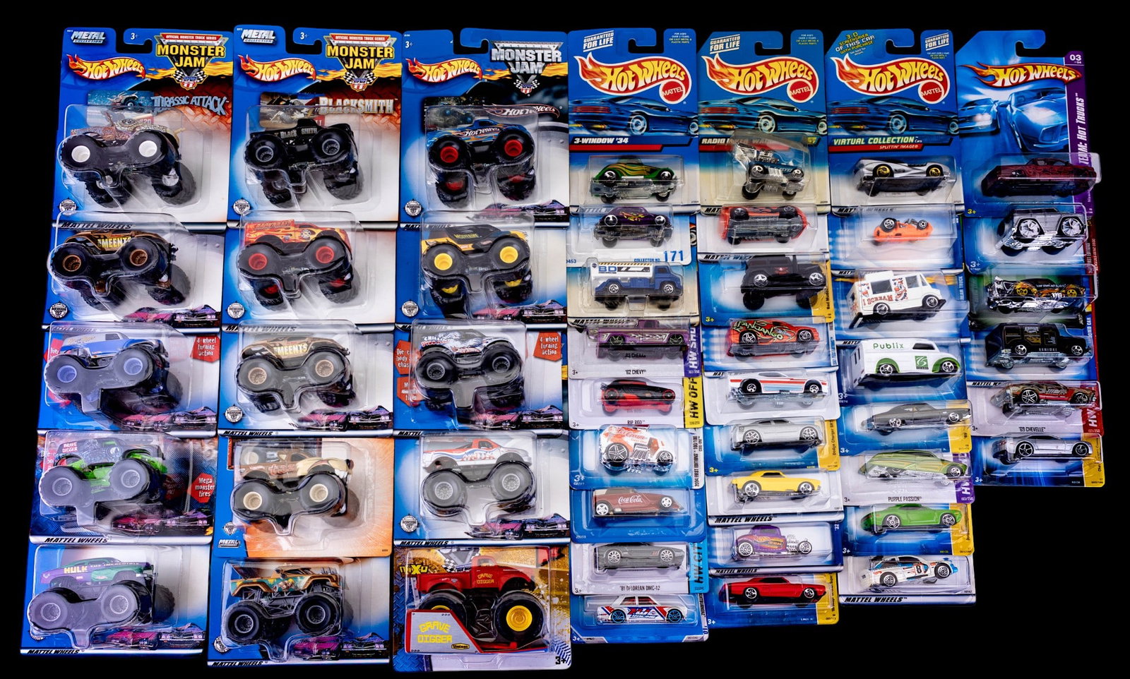Hot Wheels Die-Cast Cars & Monster Jam Trucks: Collection of approx. 32 Hot Wheels cars and 12 Hot Wheels Monster Jamp trucks, all sealed in original blister packs. Highlights among the cars include Purple Passion, '81 DeLorean DMC-12, Pontiac Ban