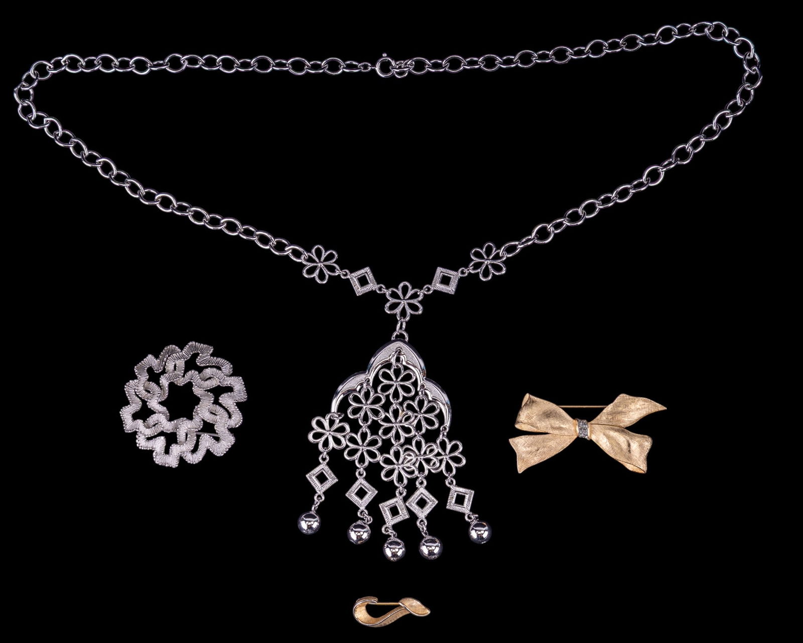 Trifari Vintage Jewelry: Includes a large silver dangle necklace and 3 brooches, all signed Trifari, circa 1980s.