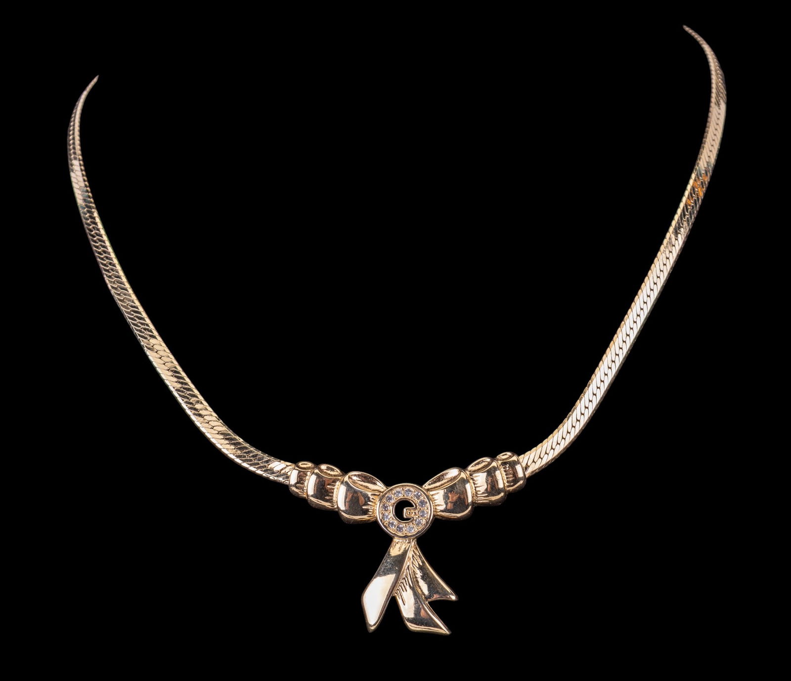Givenchy Necklace: Circa 1990s gold-tone Givenchy herringbone necklace with a crystal "G" set in central pendant.