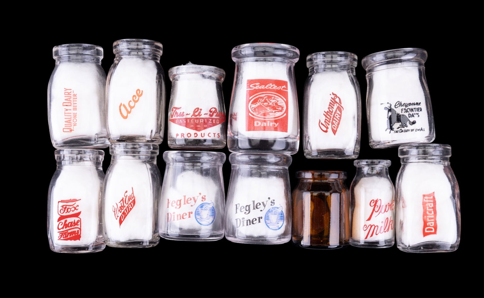 13 Vintage Dairy Creamers w/ Logos: Group of 13 vintage glass dairy creamers, each with original printed logos from various dairies and businesses including Fegley's Diner, Anthony's Dairy, and more.