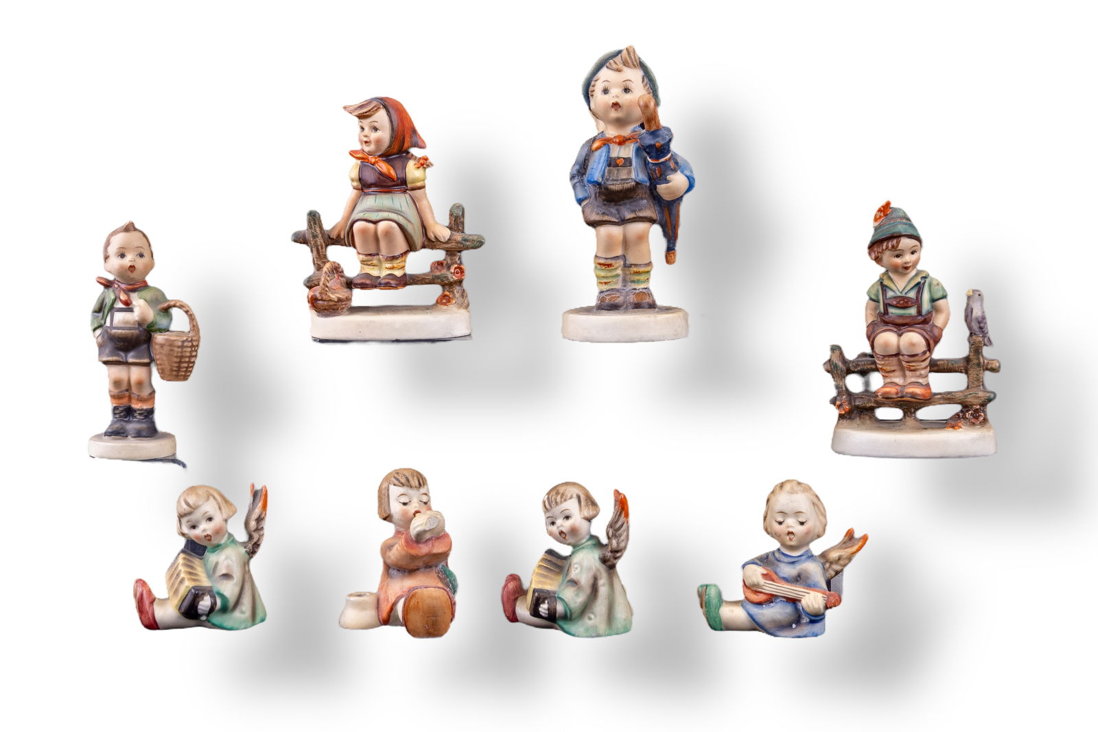 Goebel Hummel Figurines (8): A collection of 8 Goebel Hummel figurines featuring Home From Market #198 2/0, Wayside Harmony 111 3/0, Just Resting 112 3/0, Village Boy 51/1, and four Joyous News angel candlestick holder figurines.