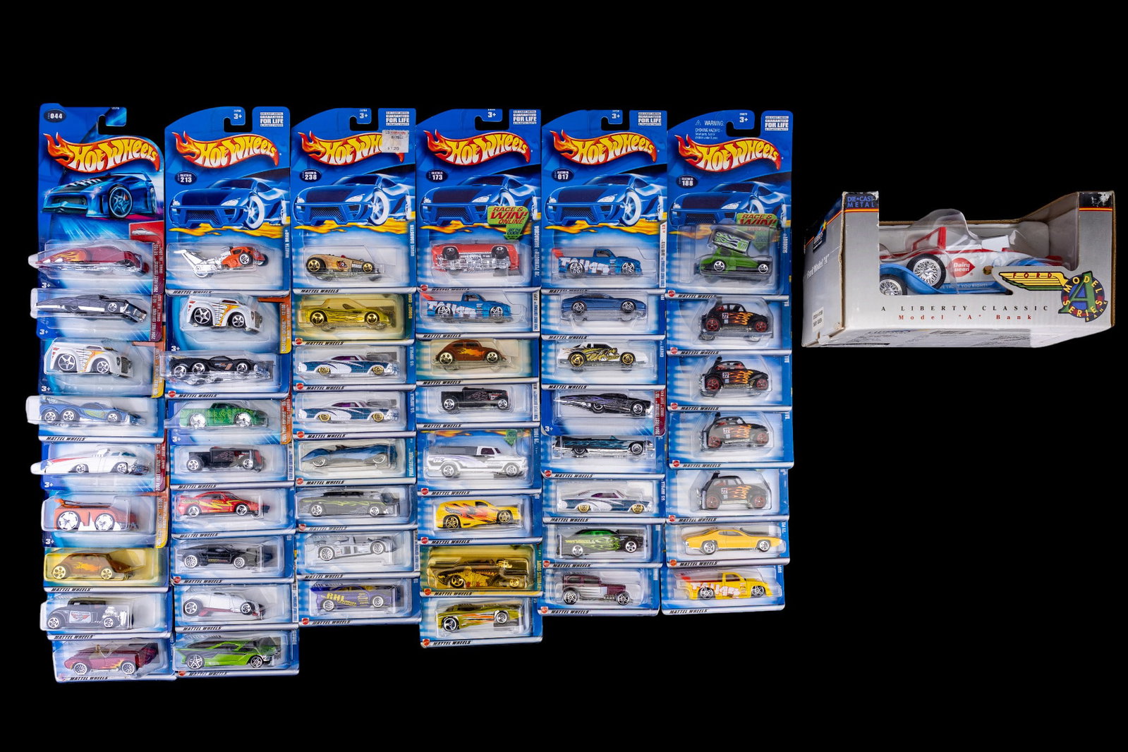 Early 2000s Hot Wheels Cars NIB: A collection of 49 NIB Hot Wheels die cast cars c. early 2000s, and a Liberty Classics Dairy Queen die cast Model A coin bank, NIB.