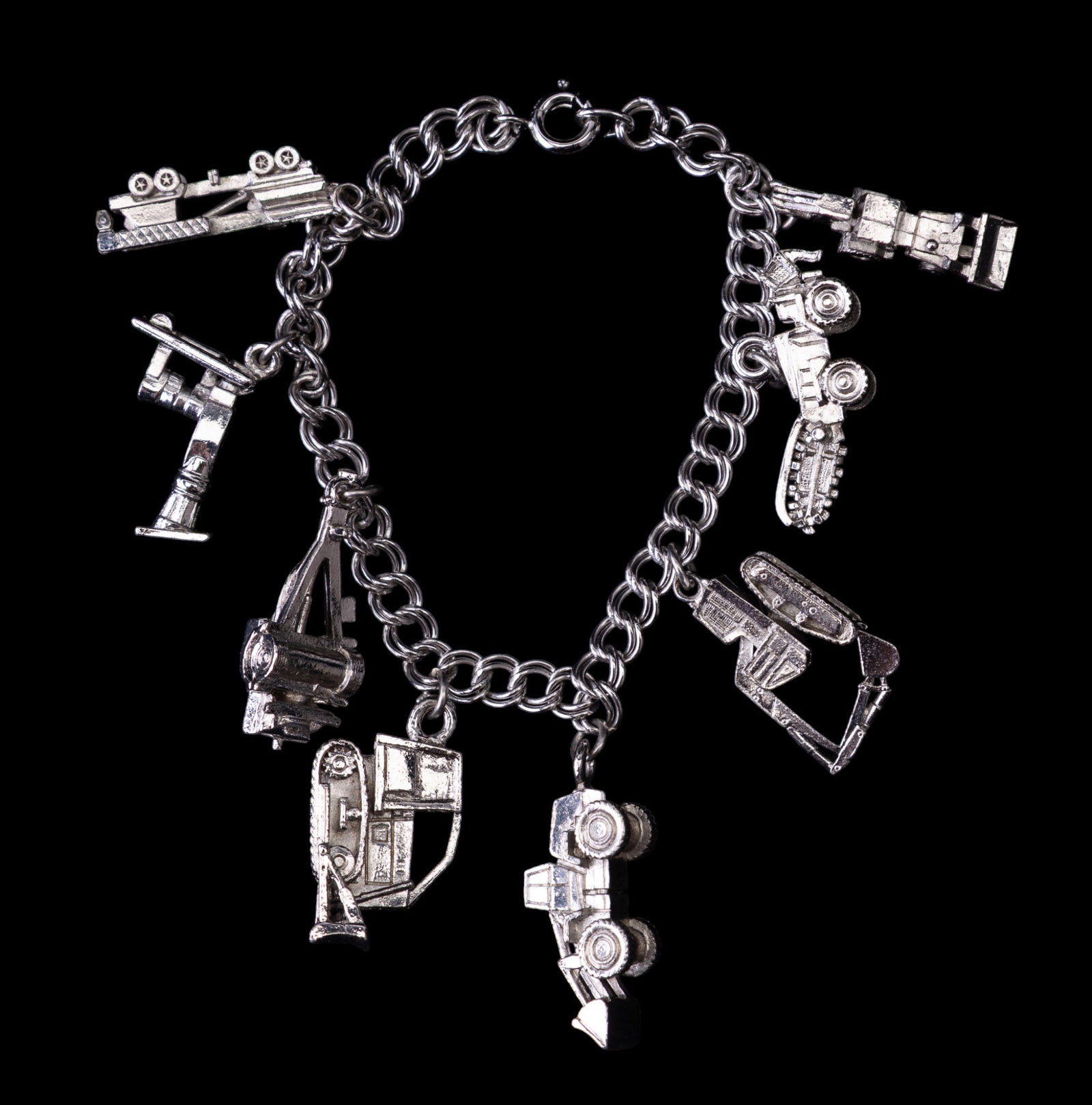Tractor and Machinery Charm Bracelet: Sterling Silver bracelet with large silver-tone charms of tractors and large machinery vehicles.