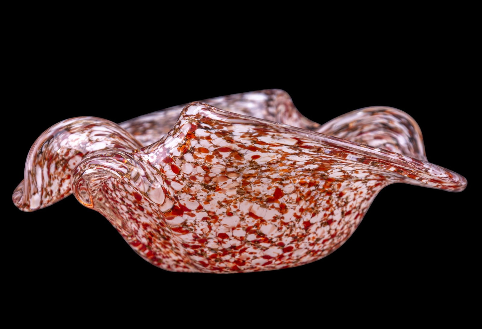 Murano Freeform Speckled Art Glass Bowl: Hand-bowl Murano art glass bowl with lobed freeform / ruffled rim and heavy cased body. The interior features dense red, orange, and white mottled inclusions, encased in clear glass. Measures approx. 