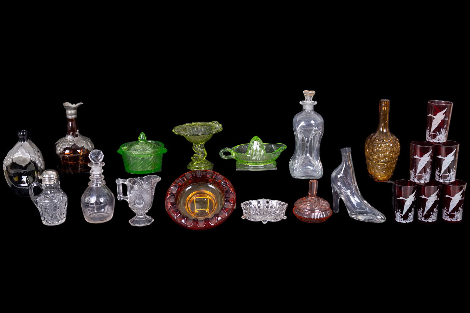 Mid Century Colored Glassware: A collection of mid century colored glassware including a set of 6 ruby glass Hazel Atlas drinking glasses with flying bird motif, a ruby to amber gradient heavy glass ashtray, 8.5" diam, a green Uran