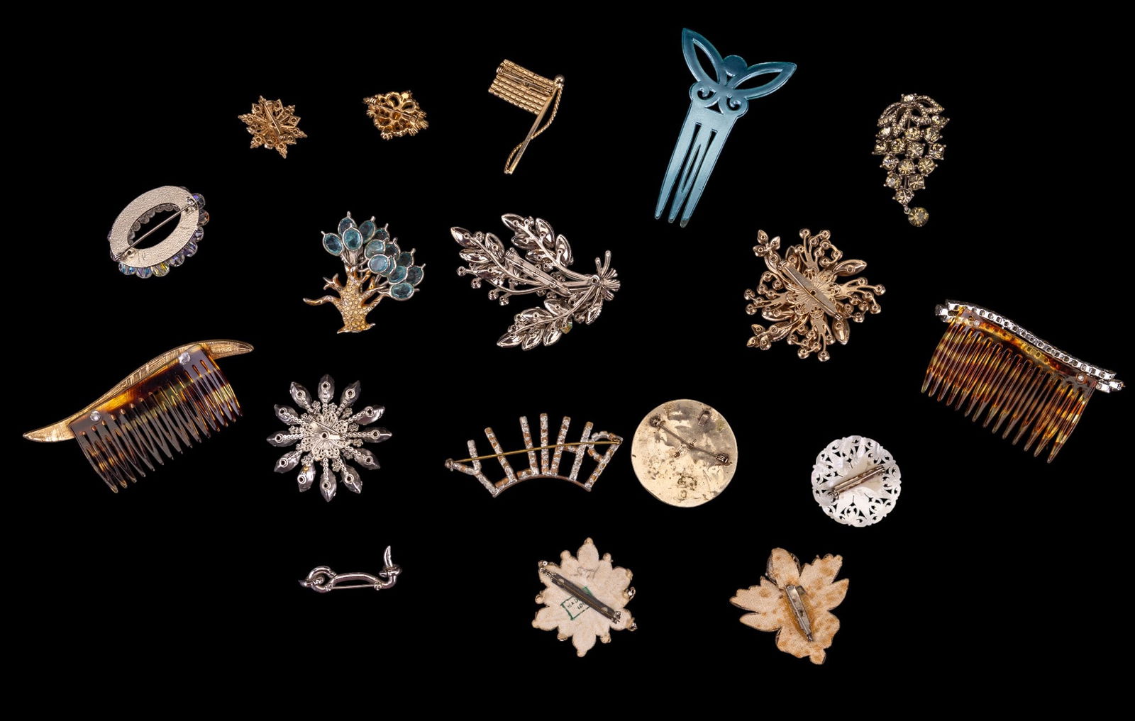 Vintage Rhinestone and Other Brooches: A collection of vintage floral motif rhinestone brooches, carved mother of pearl, abalone inlay, rhinestone and faux pearl hair combs, a blue lucite hair comb, rhinestone American Flag and 'Philly' br